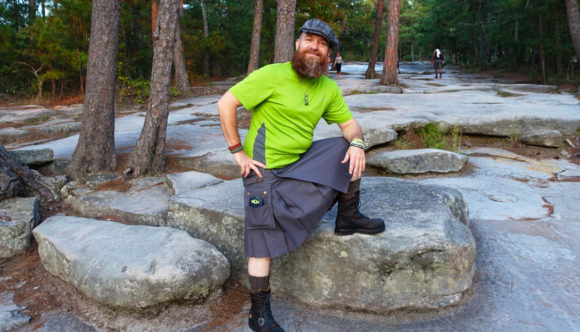 Bearded man in a kilt starting up the walk-up trail at Stone Mountain