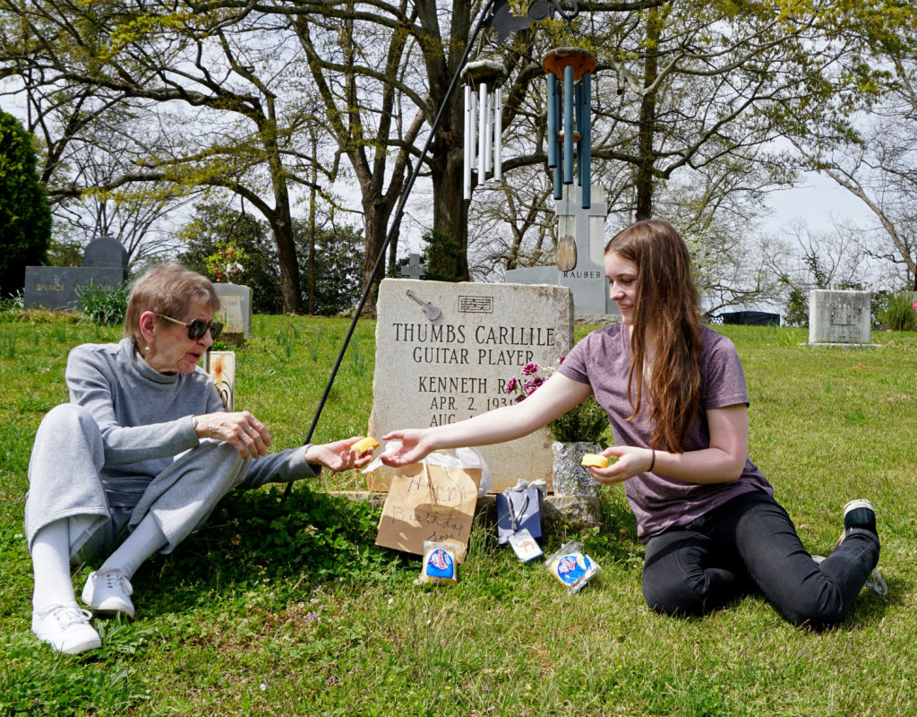 Ms. Virginia and her great granddaughter sharing a Twinkie at Thumbs Carlille's grave on his birthday.