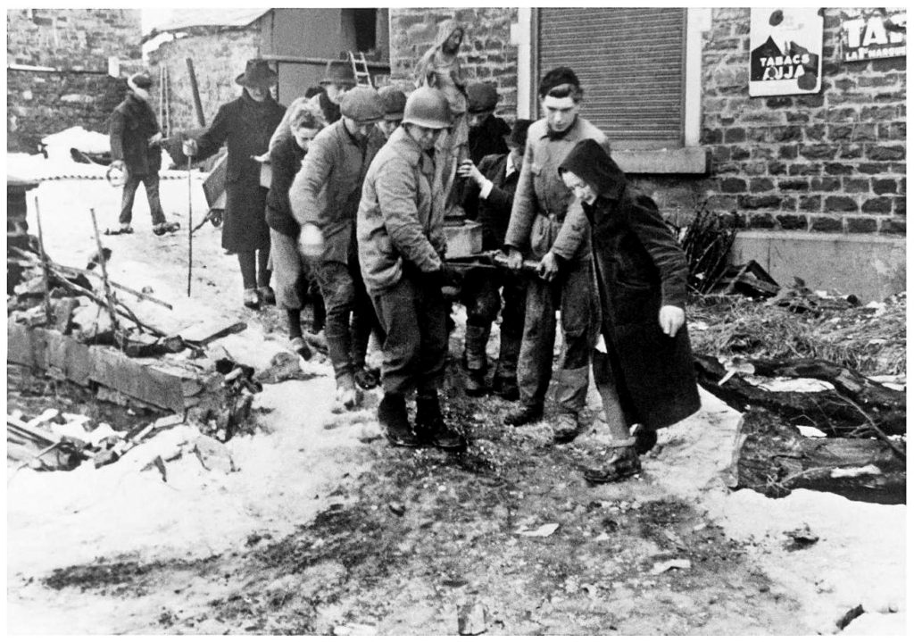📷 La Gleize, Belgium, February 1, 1945: Monuments Man Walker Hancock (from left, in U.S. Army helmet) assisted residents of the town of La Gleize with the relocation of the Madonna of La Gleize to a more secure site. (Walker Hancock Collection)